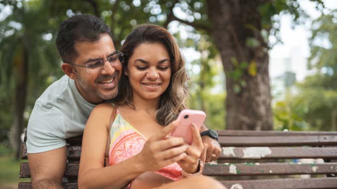Couple In The Park Taking Selfies