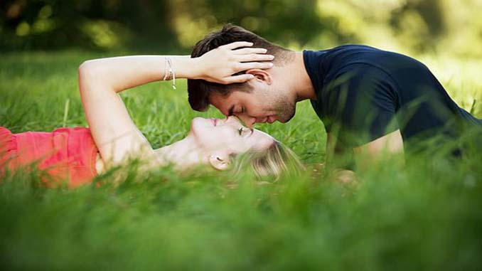 Couple Laying In The Grass In A Field