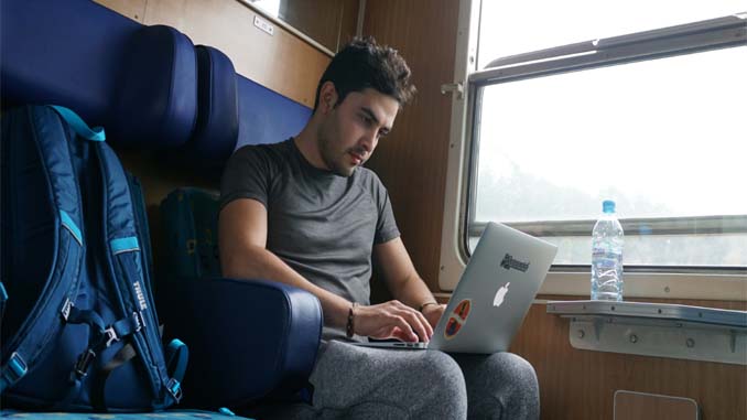 Man On Train Working On Laptop