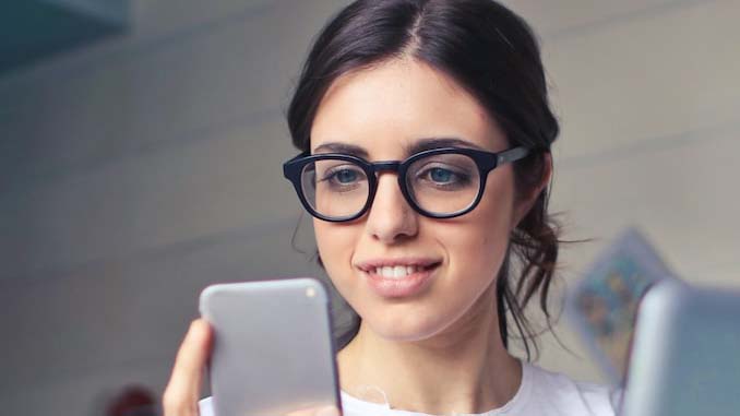 Woman Smiling With Her Phone In Her Hand