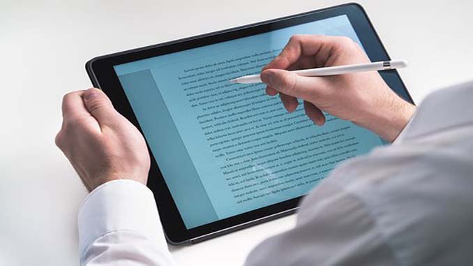 Man Editing Document On A Tablet