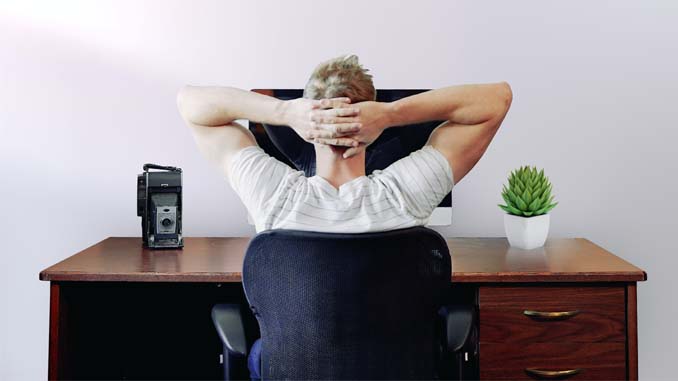 Man At Laptop With His Hands Behind His Head