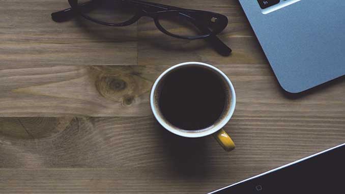 Coffee On A Desk With Glasses And A Laptop
