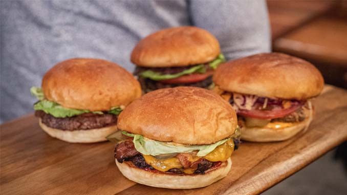 Four Hamburgers On A Cutting Board