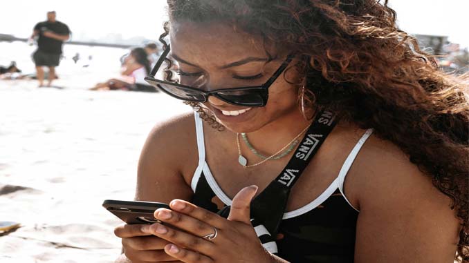 Woman On Her Phone At The Beach