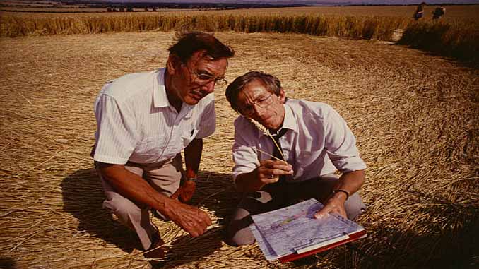 Researchers Examine A Crop Circle In A Field