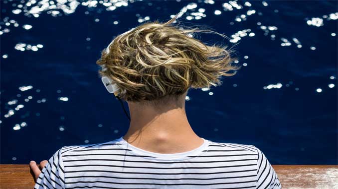 Woman With Headphones Looking Out At The Water