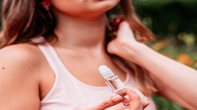 Woman Applying Essential Oils To Her Neck