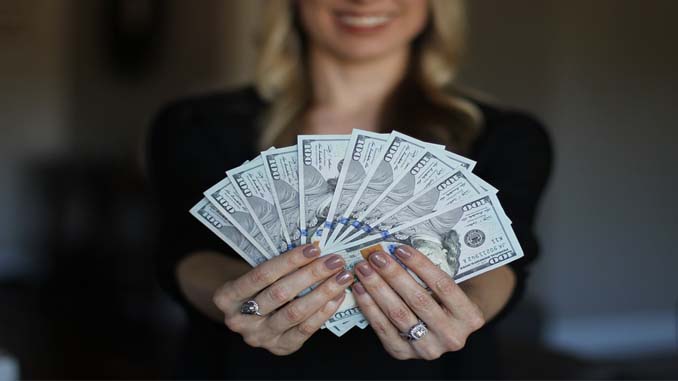 Woman Holding 10 $100 Bills