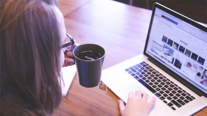 Woman At Laptop Drinking Tea