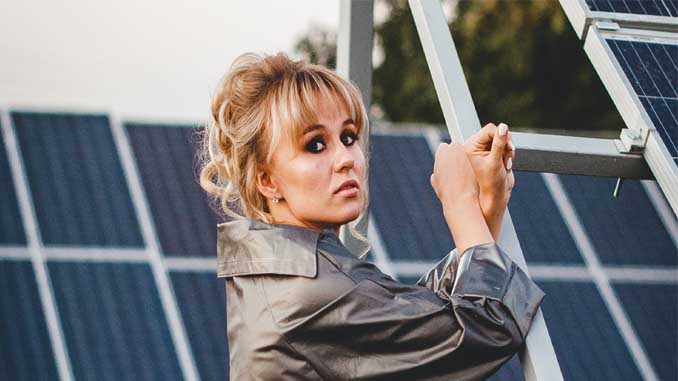 Woman Standing By Solar Panels
