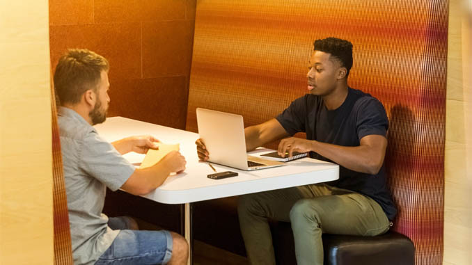 Two Men With A Laptop Talking