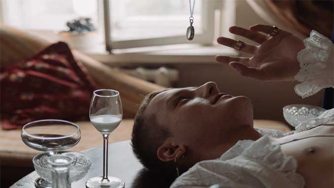 Man Laying On A Table Looking Up At A Pendulum