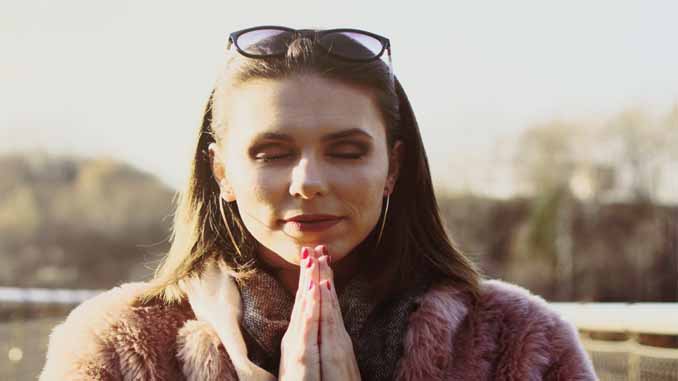 A Woman With Closed Eyes And Praying Hands