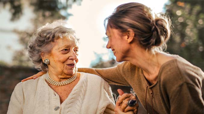 Mother And Daughter Sitting Outdoors