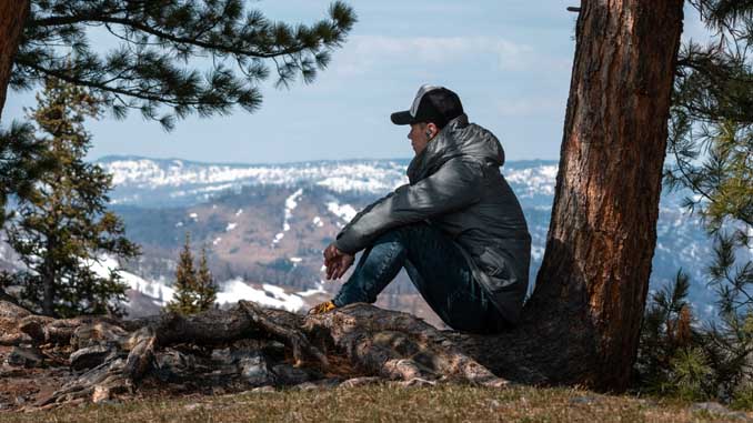 Man Overlooking A Valley