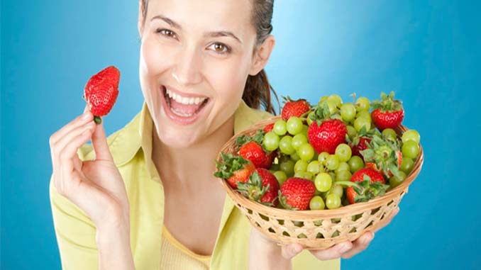 Smiling Woman Holding A Basket Of Fruit