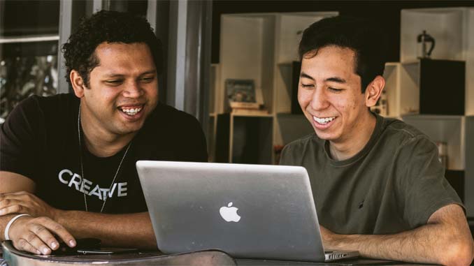 Two Smiling Men With A Laptop