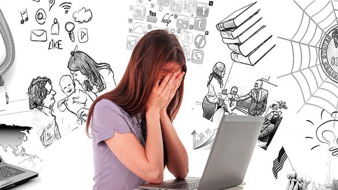 Woman At Laptop With Her Head In Her Hands