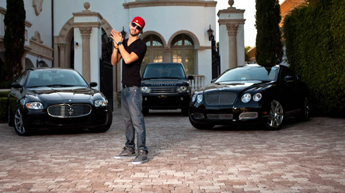 Young Man Standing In Front Of Three Luxury Cars