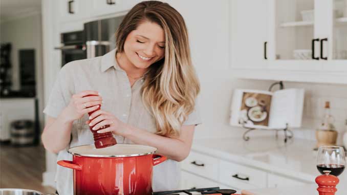 Woman Adding Seasonings To A Pot