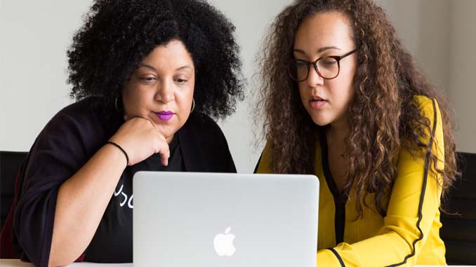 Two Women Working At A Laptop