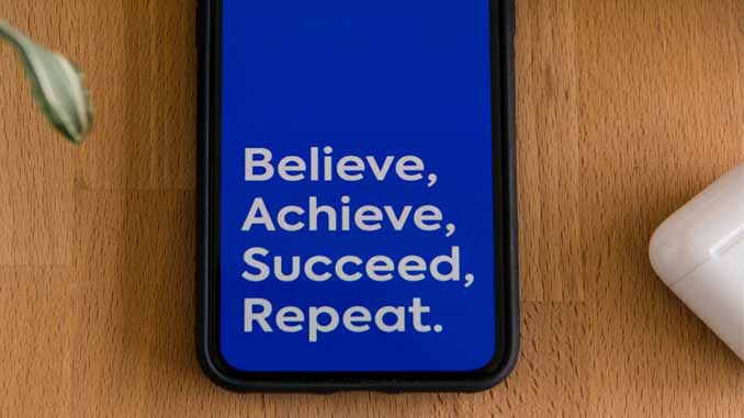Cellphone Screen Reading "Believe, Achieve, Succeed, Repeat"