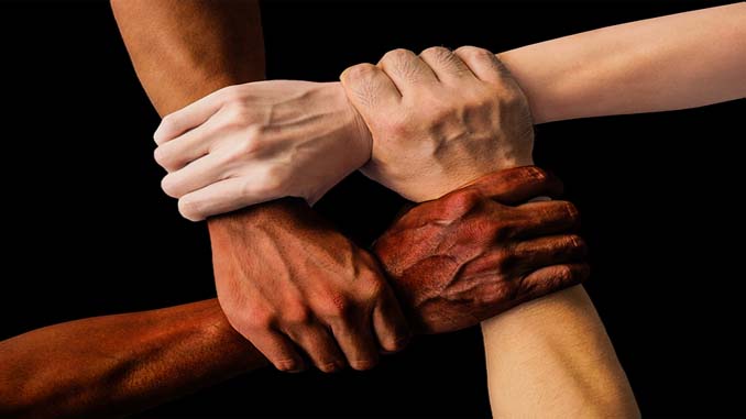 Four People With Hands Linked At The Wrist