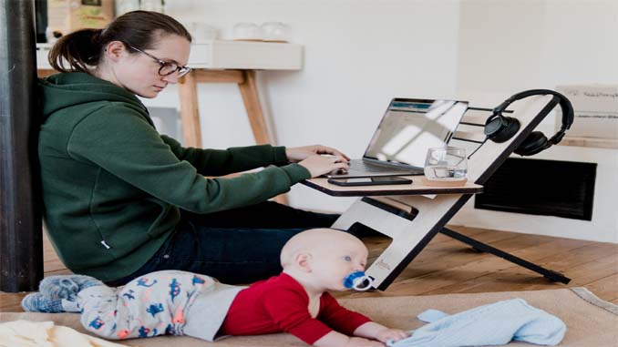 Woman Working On Laptop With Her Baby