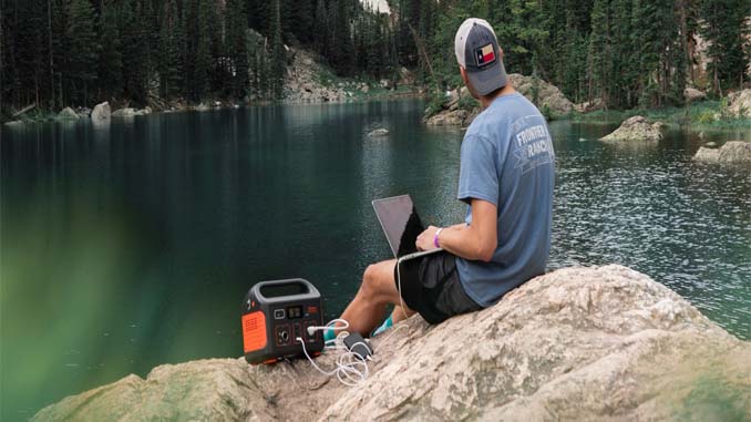 Man Using Solar Powered Laptop At The Lake