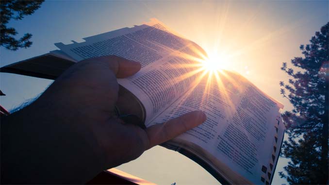 A Man Holding An Open Bible