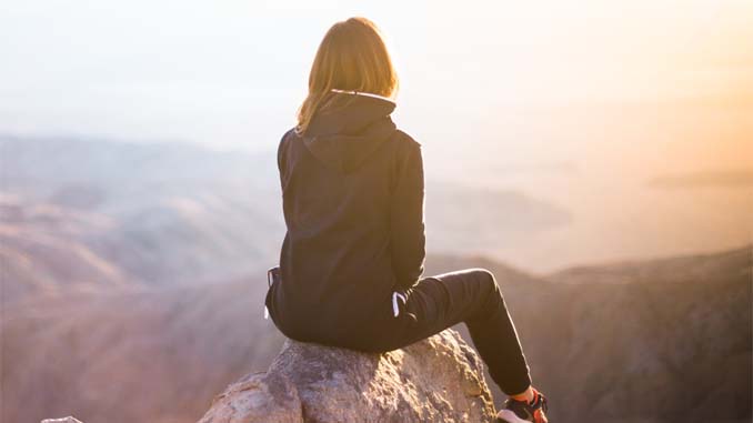 Woman Sitting On A Mountain Top