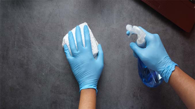 Gloved Hands Cleaning A Surface