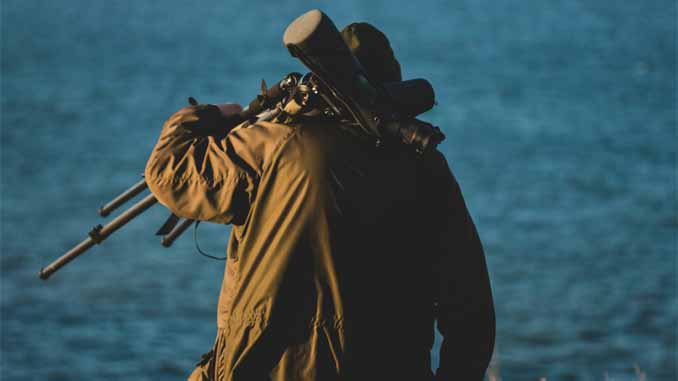 Man Carrying His Camera And Tripod