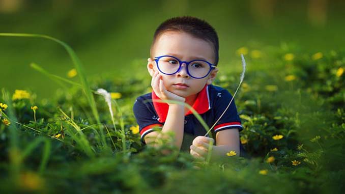 Young Boy Laying Down In A Field