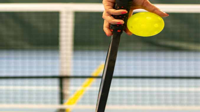 Woman Holding A Pickleball Paddle And Ball
