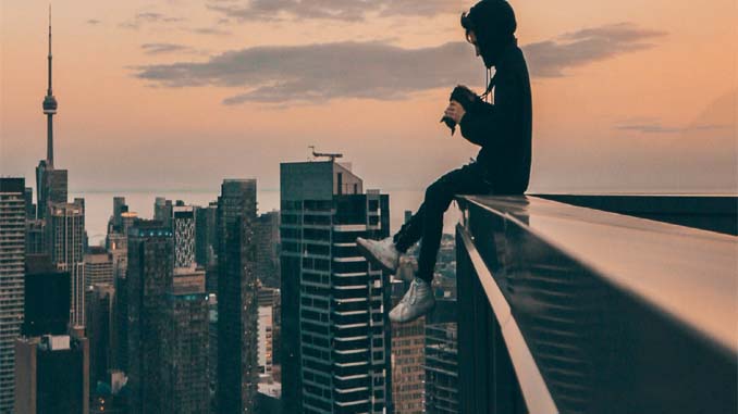 An Individual Sitting Alone On The Roof Taking Pics