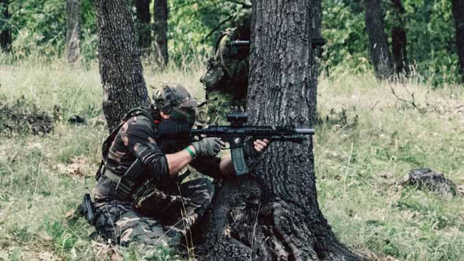Two Players Taking Cover Behind A Tree