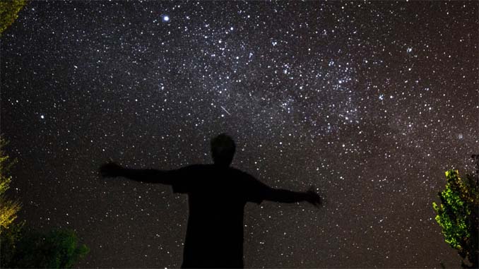 Man Looking Up At Stars With Outstretched Arms