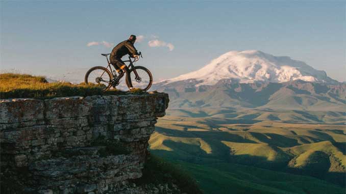 Man On Cliff With His Bike