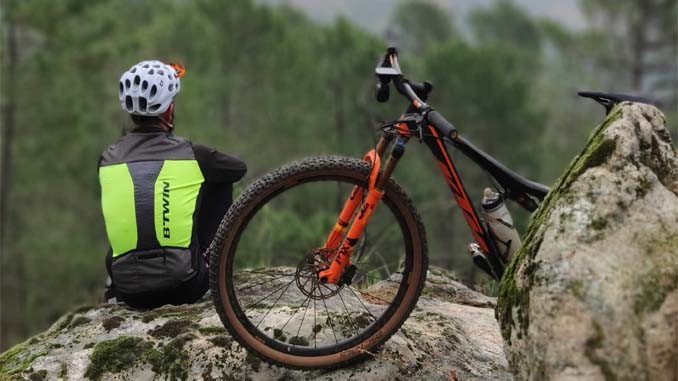 Man Sitting On A Cliff With His Bike