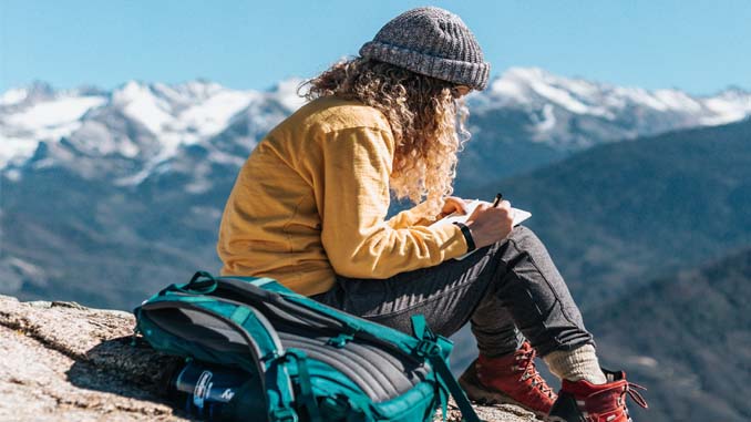 Woman Journaling On A Cliff