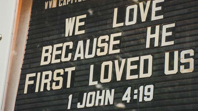 Sign Reading "We Love Because He First Loved Us"